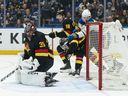 Vancouver Canucks goalie Thatcher Demko is scored on while Buffalo Sabres' Zach Benson (right) and Canucks' Tom Willander battle at the side of the net during game in Vancouver on Thursday, Dec. 11, 2025.