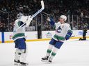 Vancouver Canucks goaltender Kevin Lankinen, left, celebrates with Brock Boeser, right, after a 3-2 shootout win over the Seattle Kraken on Monday night in Seattle.