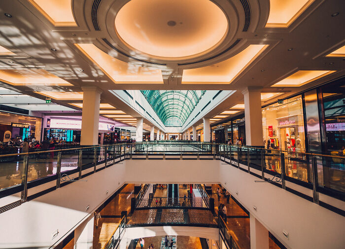 Interior view of Dubai Mall with shoppers and stores amid reports of a crypto scammer case linked to dismemberment.