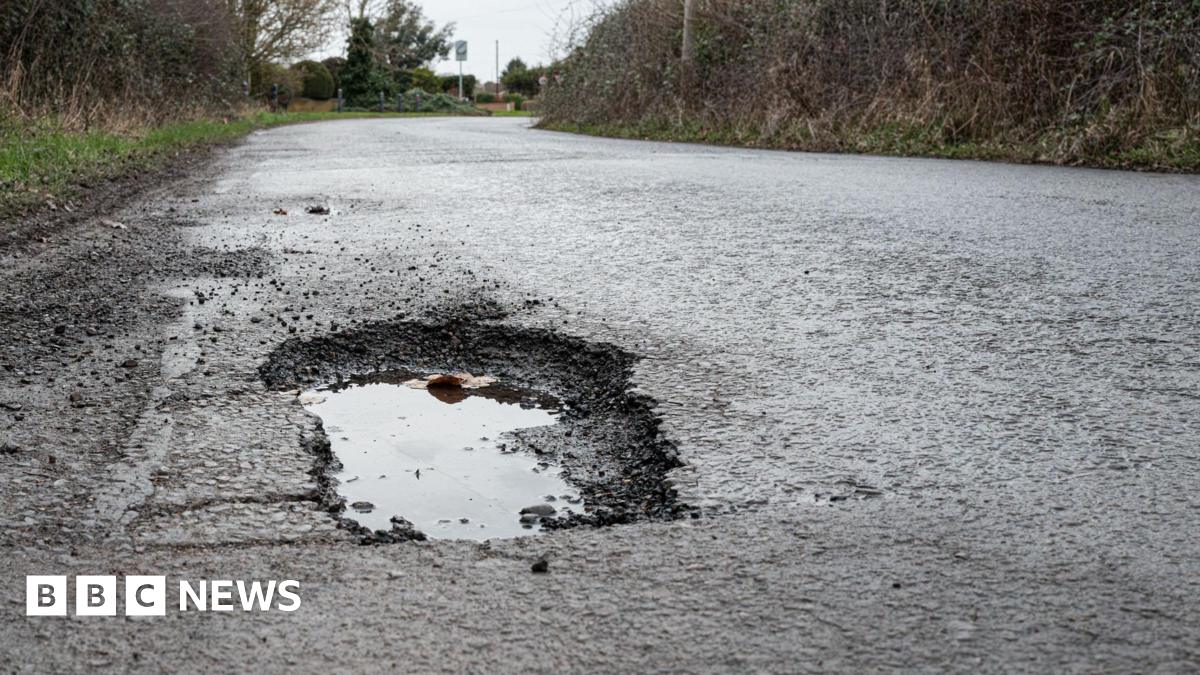A pothole filled with water on a rural road