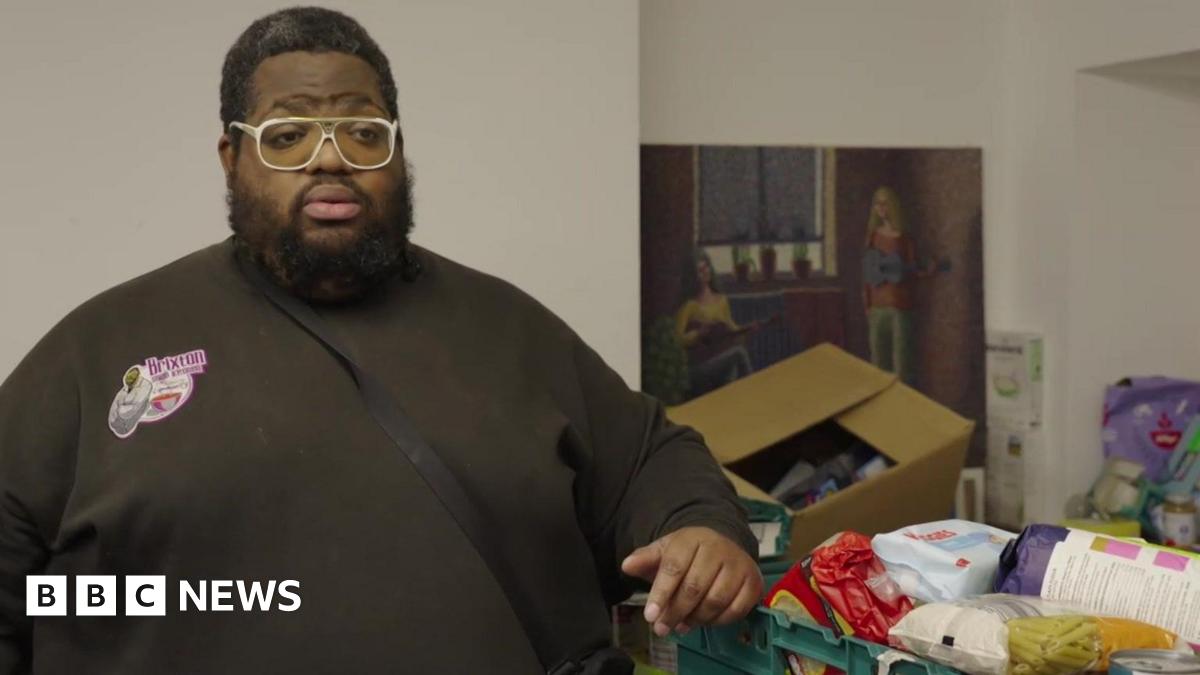 Solomon Smith leans one arm on a green crate of donated food.