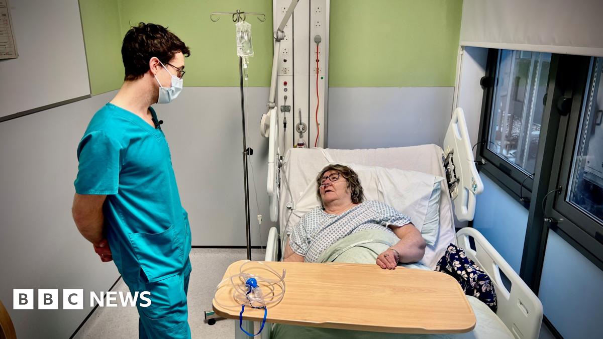 A woman coughs into her hand.