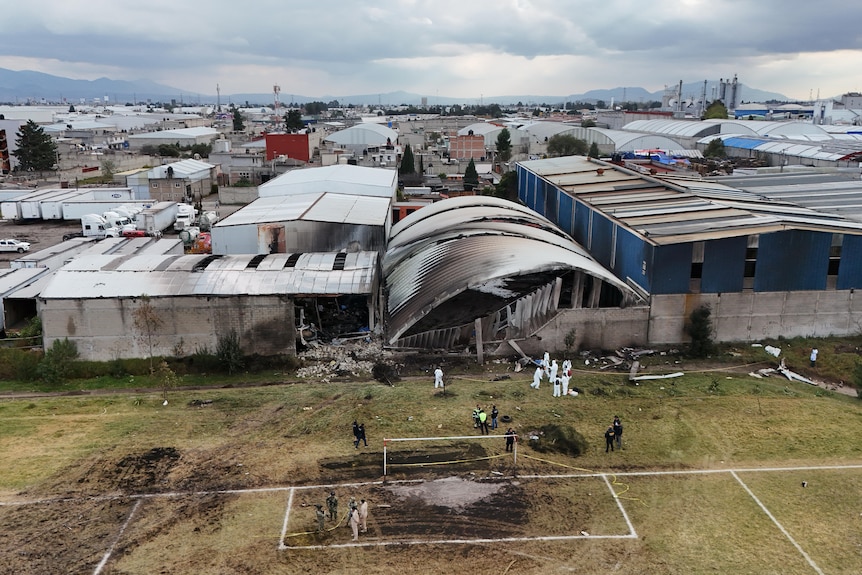 An aerial shot shows scorched grass at the crash site as rescue workers attend the scene.