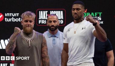 Jake Paul and Anthony Joshua hold up their fists as they pose for pictures side-by-side