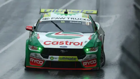 Getty Images A green Ford racing car with a Castrol sponsorship logo on the bonnet. 