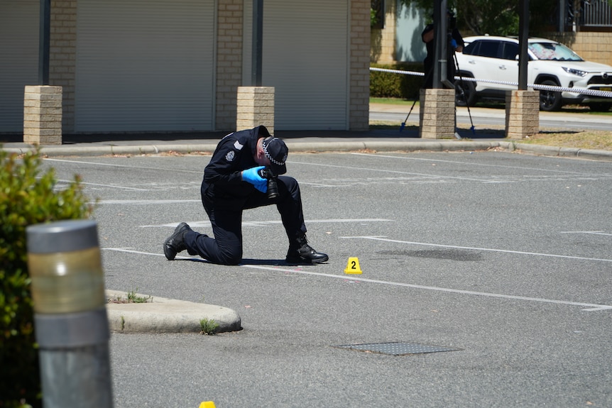 Police search a car park for clues in a murder investigation