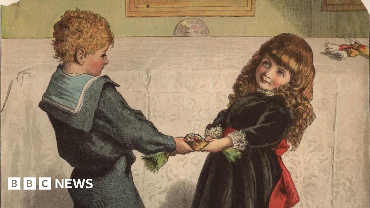 December 1878: Little Katie and Johnny wrestle with a Christmas cracker. (Photo by Rischgitz/Getty Images)