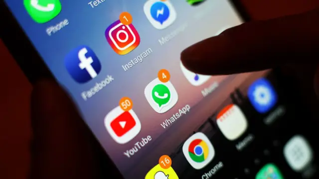 A close-up image of a phone screen with different social media apps on the screen