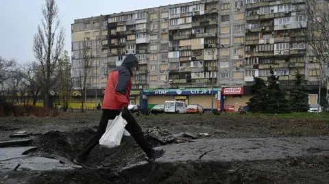 Getty Images A man walking over an explosion site