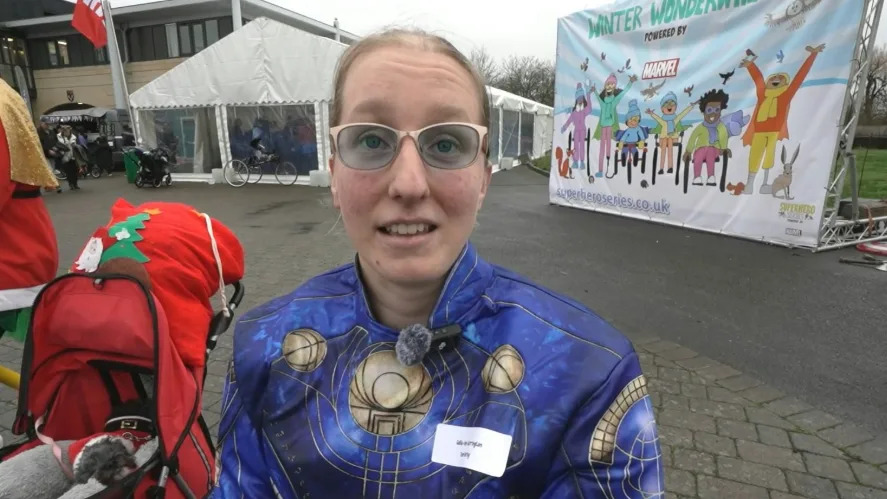 Callie-Ann Warrington smiling at the camera is wearing a marvel suit and glasses.