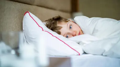 Getty Images A stock image of a boy looking sick in bed.