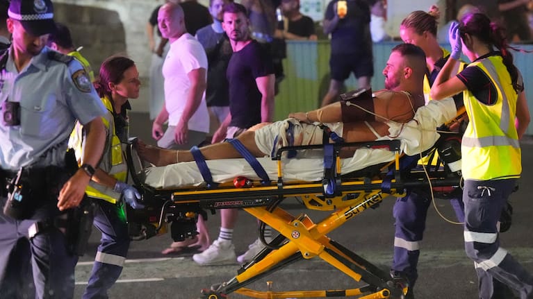 Emergency workers transport a person on a stretcher after a reported shooting at Bondi Beach in Sydney