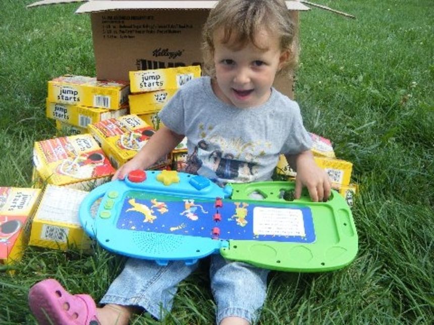 Kim Neubacher's daughter Angel plays with an educational toy given by the family's sponsor, who also donated boxes of cereal bars.