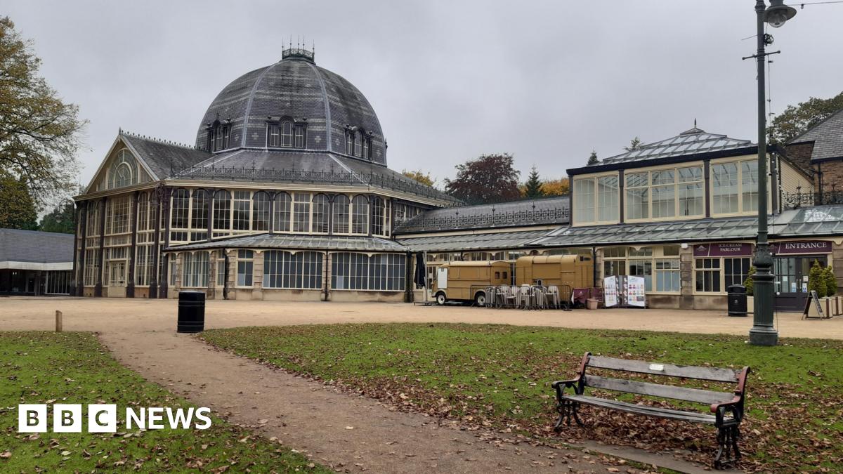 A bench in front of a dome structure with grey skies behind