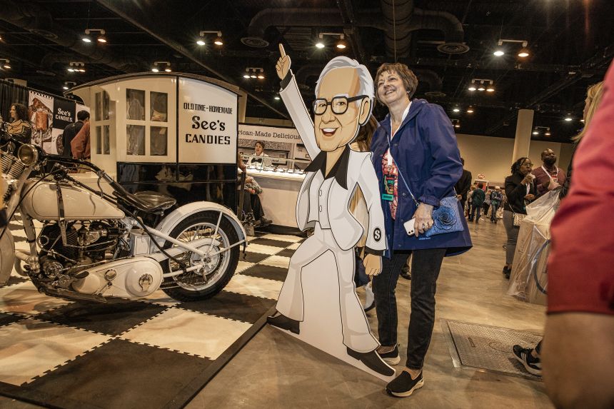 An attendee takes a photo next to a Warren Buffett cutout during a shareholders shopping day ahead of the Berkshire Hathaway annual Attendees meeting in 2023.