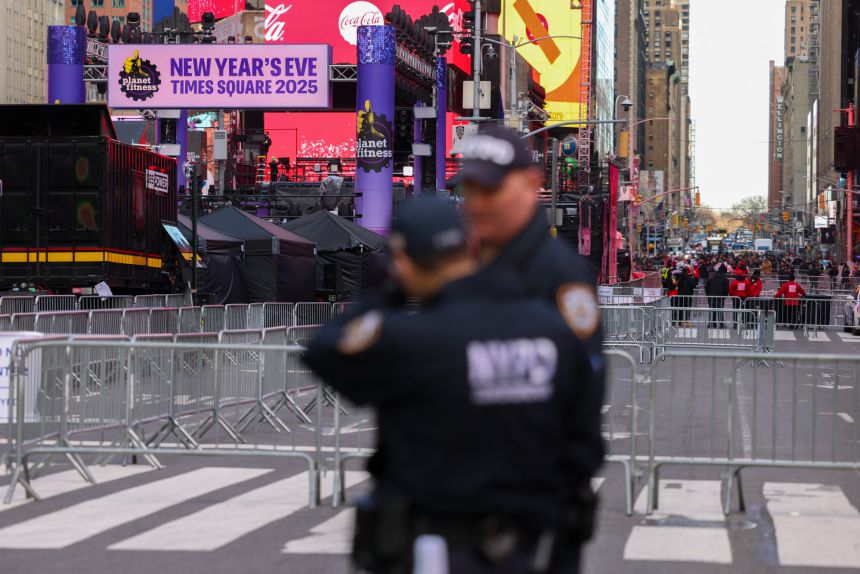 New York City police officers stand watch in Times Square ahead of the New Year's Eve celebration on December 31, 2024.