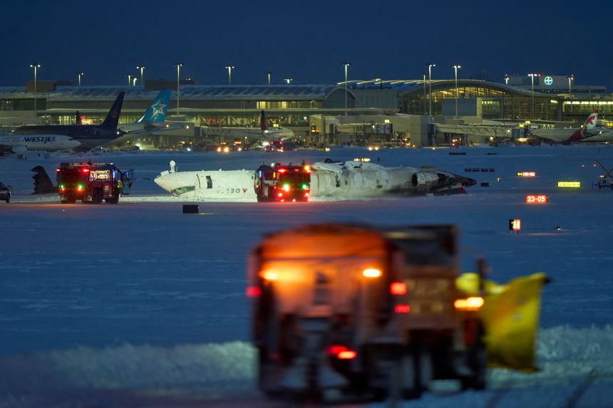A Delta airlines plane sits on its roof after crashing upon landing at Toronto Pearson Airport in Toronto, Ontario, on February 17, 2025. A Delta Air Lines jet with 80 people onboard crash landed at the Toronto airport, officials said.