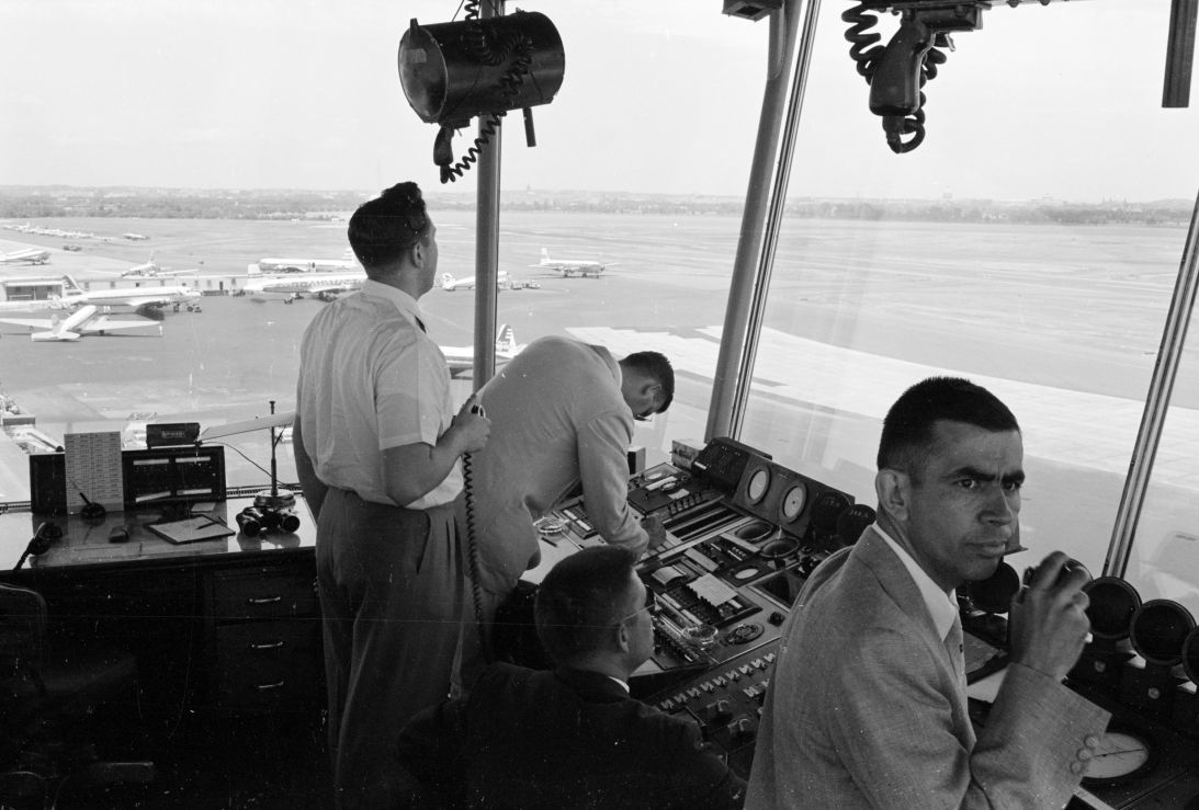 Air traffic controllers monitor equipment while looking out the windows at Washington National Airport in Arlington, Virginia, on June 17, 1958.