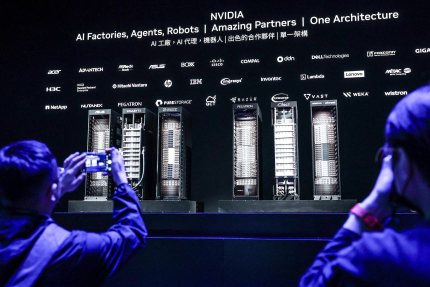 Participants take pictures of Nvidia GPUs on the stage after Nvidia CEO Jensen Huang gave the first keynote speech of Computex 2025 at the Taipei Music Center in Taipei on May 19.