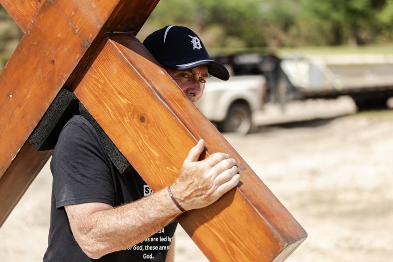 Beazley walks up the bank of the Guadalupe River while carrying his cross on July 8 in Ingram, Texas, after heavy rainfall caused fatal flooding along the river in central Texas.
