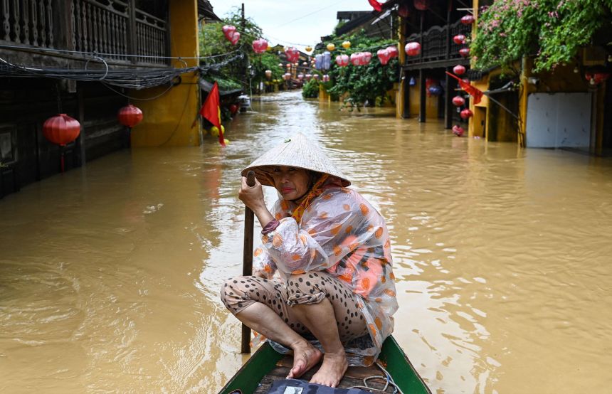 A woman rows a boat on a flooded street following heavy rains in Hoi An, Vietnam on October 30, 2025.