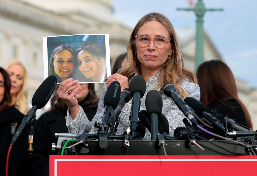 Epstein abuse survivor Annie Farmer holds up a photo of her younger self with her sister Maria Farmer during a news conference with lawmakers on the Epstein Files Transparency Act outside the U.S. Capitol on November 18, 2025.
