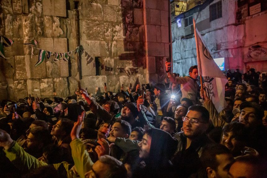 Crowds wait outside Umayyad Mosque in Damascus, as President Ahmad al-Sharaa prays inside, on the morning of the first anniversary of the fall of the Assad regime.