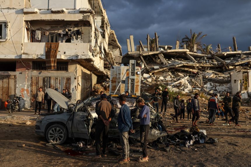 Palestinians inspect the remains of a destroyed vehicle targeted by the Israeli military in Gaza City, Palestine, on December 13, 2025. Gaza's civil defense agency says four people are killed in an Israeli airstrike on the Palestinian territory on December 13.
