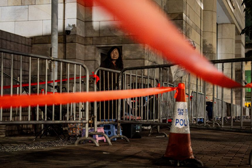 People wait outside the West Kowloon Law Courts Building in Hong Kong on December 14, 2025, ahead of Lai's verdict.