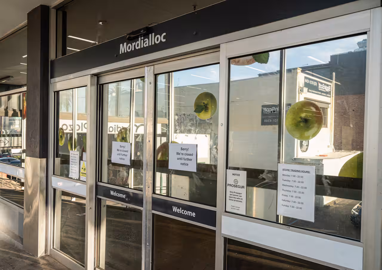  A shopfront with notices on its glass doors saying it is closed until further notice