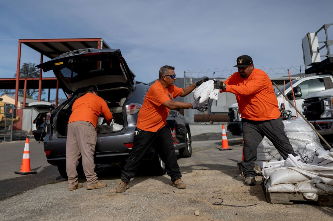 Workers with the Los Angeles County Public Works Department distribute sandbags to residents in Altadena, California, on Monday.