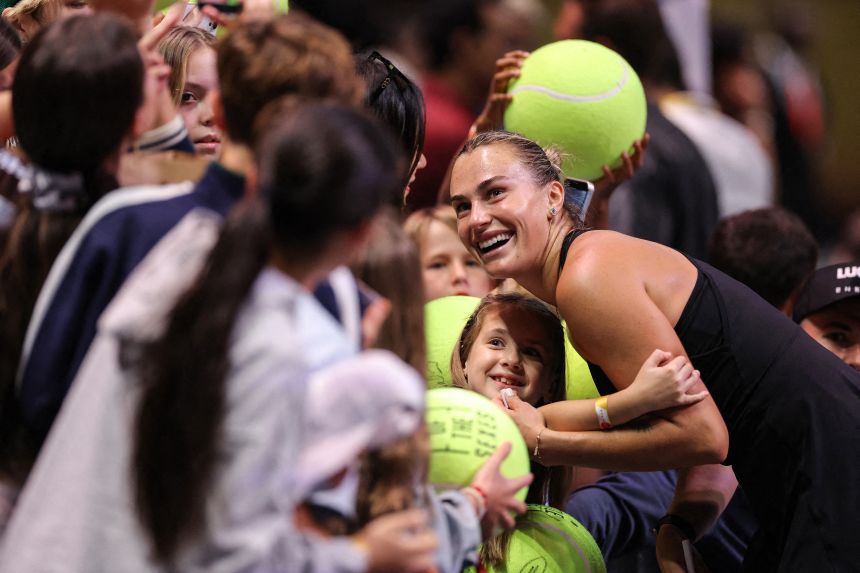 Aryna Sabalenka poses with fans after exhibition tennis match against  Nick Kyrgios in Dubai.