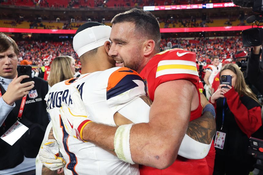 Travis Kelce (right) hugs Evan Engram #1 of the Denver Broncos following the Broncos' 20-13 win at Arrowhead Stadium.