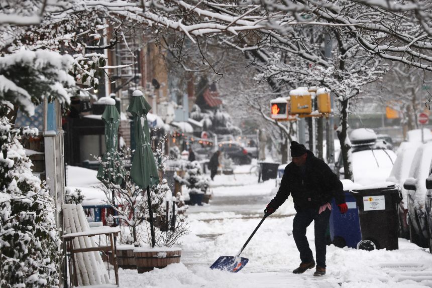 A man shovels snow in Brooklyn Saturday after an overnight storm.