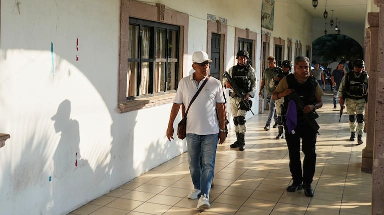 Guadalupe Mora walks with protection from police and the National Guard in La Ruana, Michoacan state.