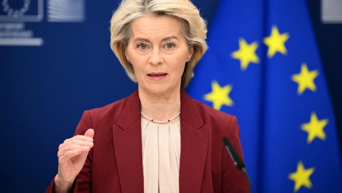 Ursula Von der Leyen speaks at a podium with an EU flag in the background during a NATO press conference.