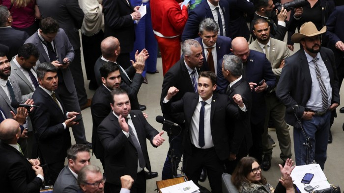 Lawmakers and supporters, some cheering and raising fists, react during a session at the Chamber of Deputies in Brasília.