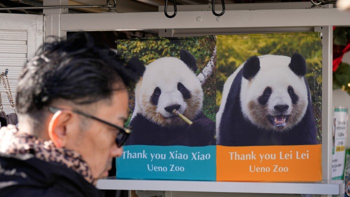 A man walks past pictures of giant pandas Xiao Xiao and Lei Lei at Ueno Zoo in Tokyo on Tuesday,