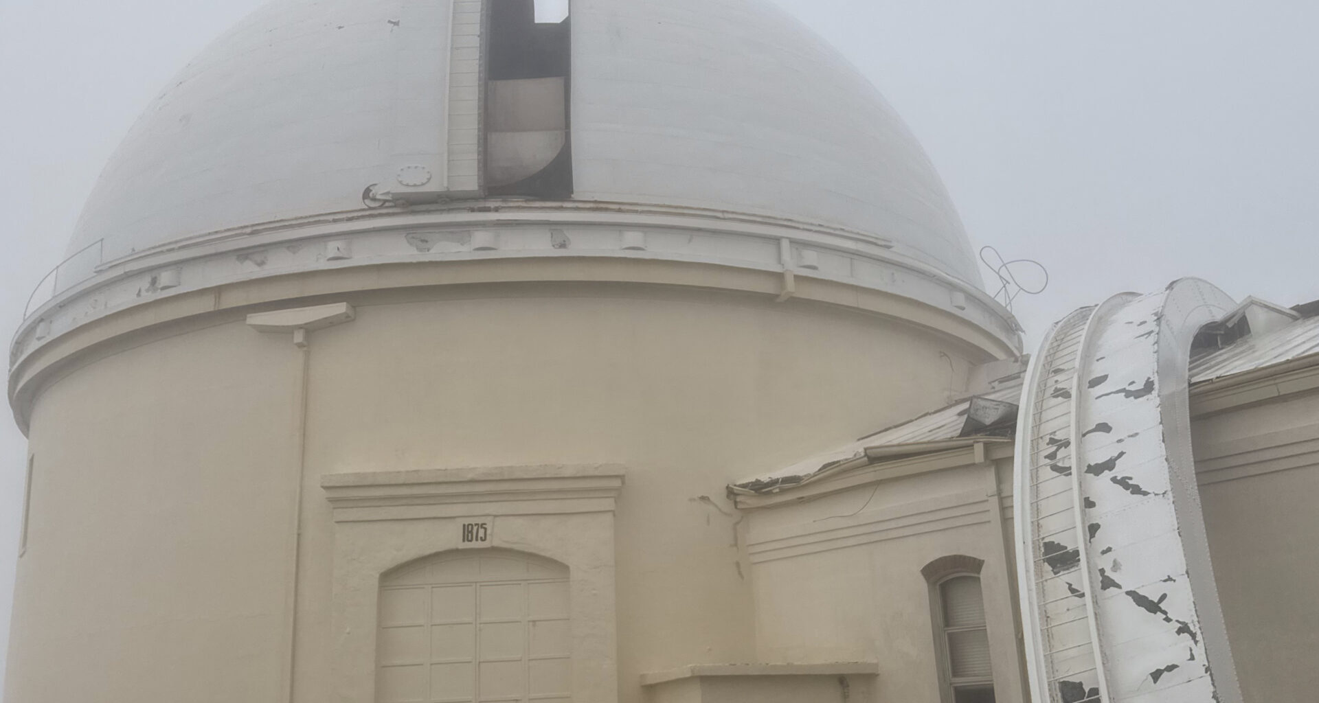 Exterior of observatory with part of the shutter on top of an adjacent building.