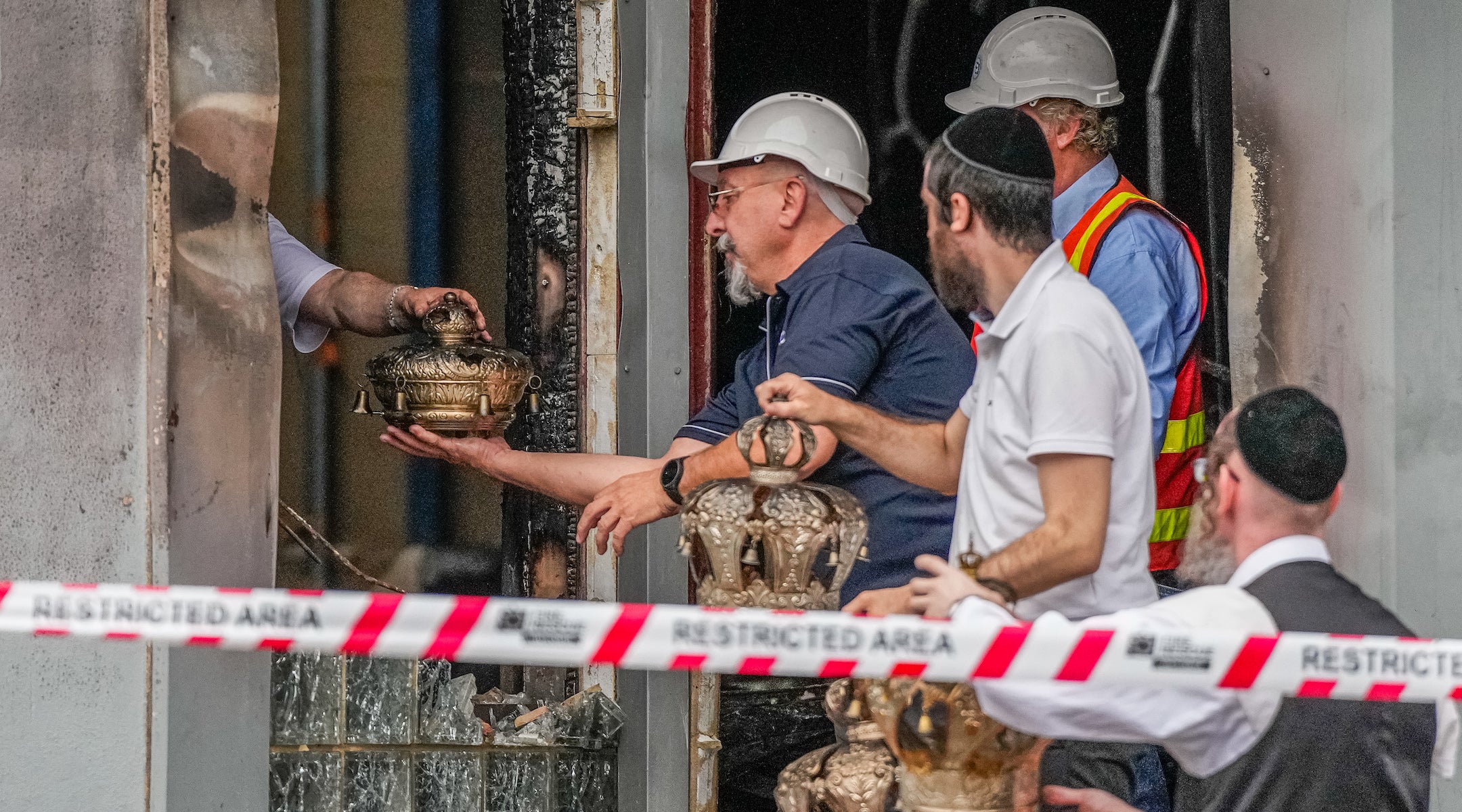 A photo of congregants pulling burnt items from the synagogue in melbourne.