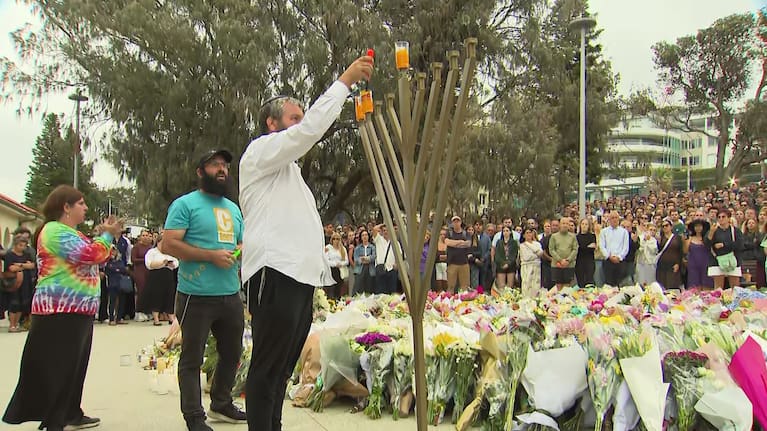 Mourners gather at a vigil for the victims of the Bondi beach shooting yesterday. 