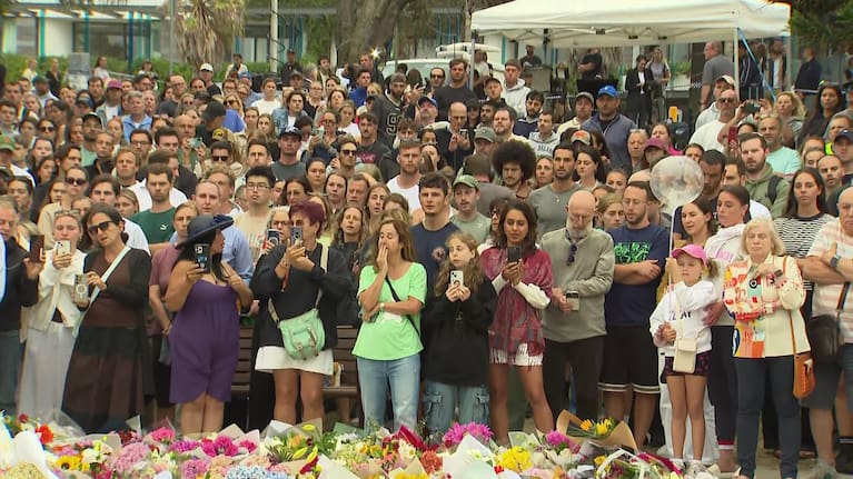 Mourners gather at a vigil for the victims of the Bondi beach shooting yesterday. 