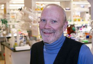 Stephen Betz close up with his laboratory equipment behind him.