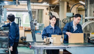 Industrial packaging and assembly line with workers in uniform managing production tasks