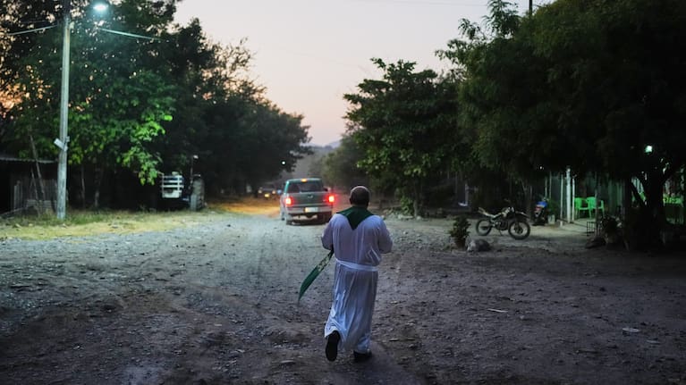 Rev. Gilberto Vergara walk toward a house to blesses a person in Apatzingan in the Michoacan state of Mexico.