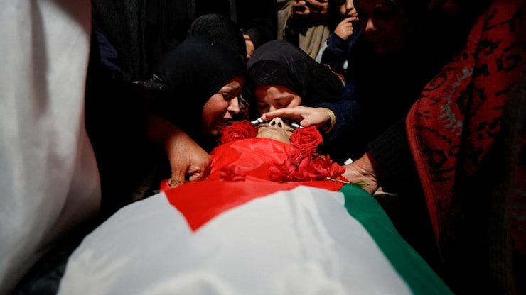 Sameeha Sabbah, mother of 16-year-old Palestinian Ammar Sabbah, who was killed by Israeli soldiers in a West Bank raid, reacts next to her son's body during his funeral near Bethlehem in the Israeli-occupied West Bank, on Tuesday. 
