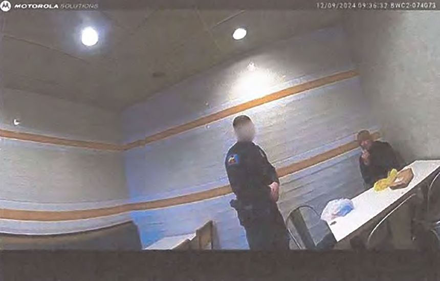 Luigi Mangione is seen being questioned by police in McDonald's in stills from body camera footage. A portion of this image has been obscured by the source.