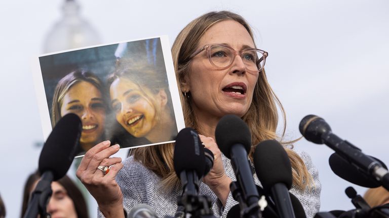 Annie Farmer holds a photo of herself and her sister, Maria Farmer, when they were victims of Epstein. Pic: AP