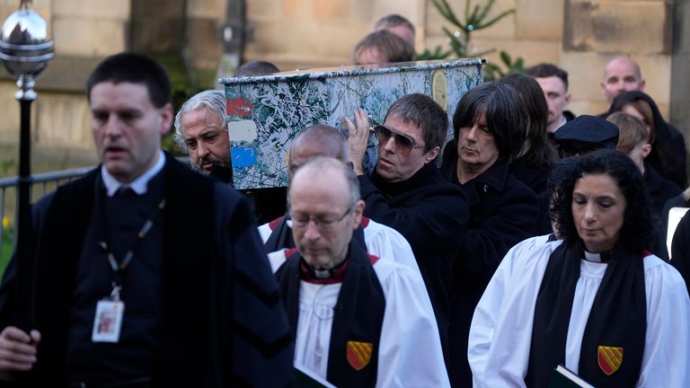 The coffin is carried from the ceremony by Alan Wren (L), Liam Gallagher (R) and John Squire (2nd R). Pic: PA