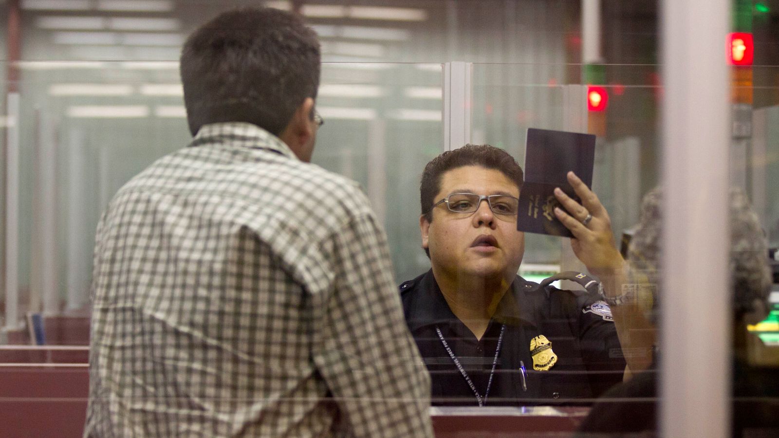 A Customs and Border Protection officer checks the passport of a tourist to the US. File pic: AP